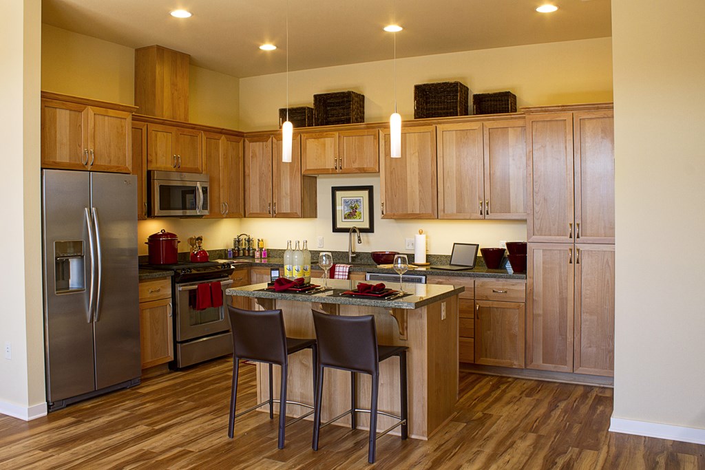 a large kitchen with stainless steel appliances and wooden cabinets