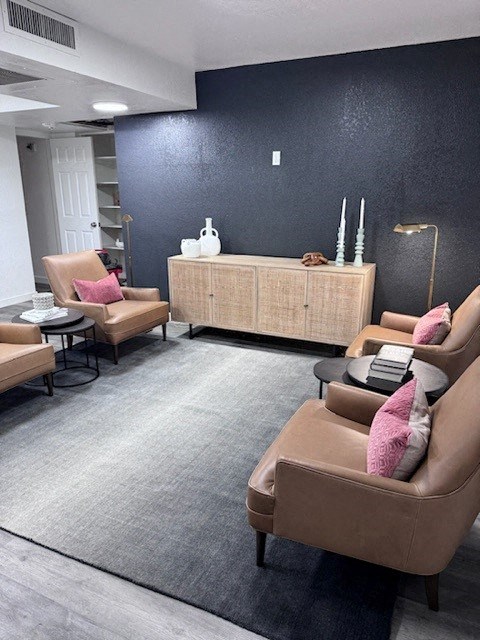 a living room with couches and chairs and a black wall