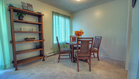 a dining room with a table and chairs and a book shelf