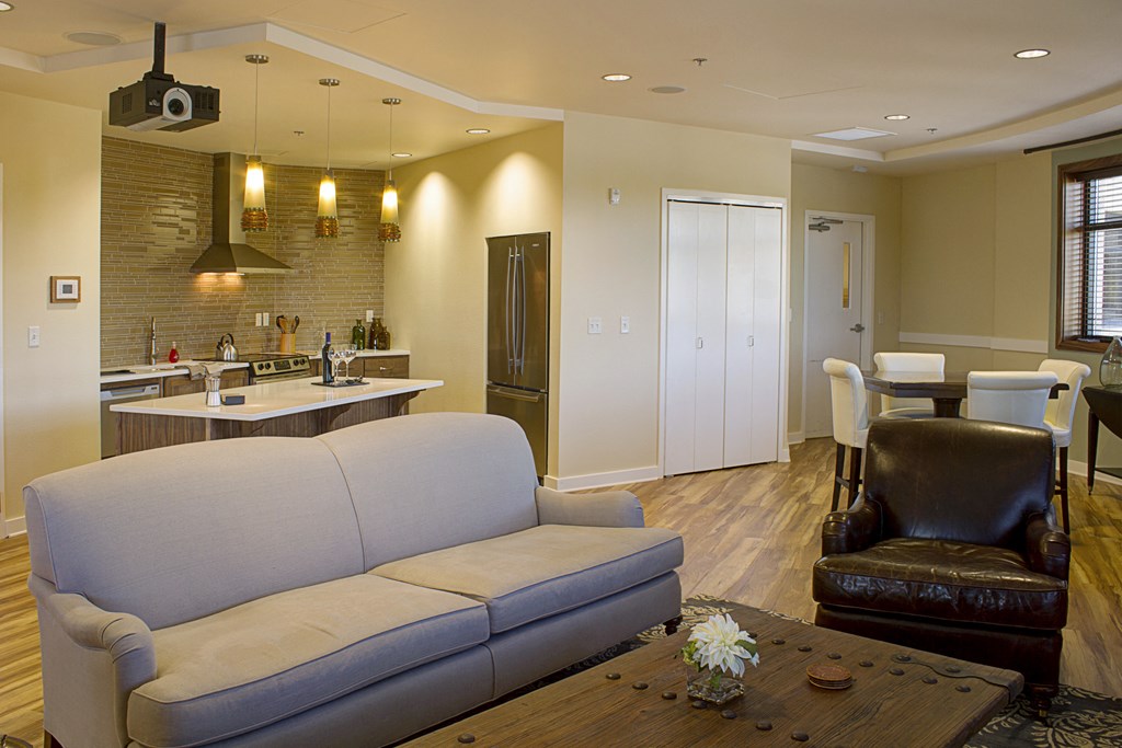 a living room and kitchen with a couch and a table