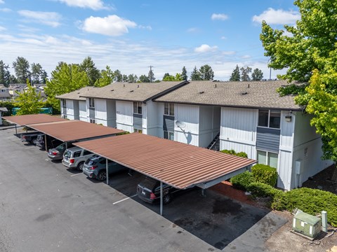 A parking lot with cars and a building in the background.