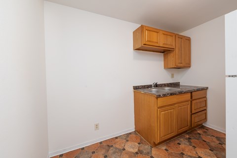A kitchen with a wooden cabinet and a granite countertop.