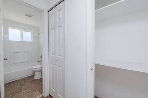 A white bathroom with a toilet and tub.