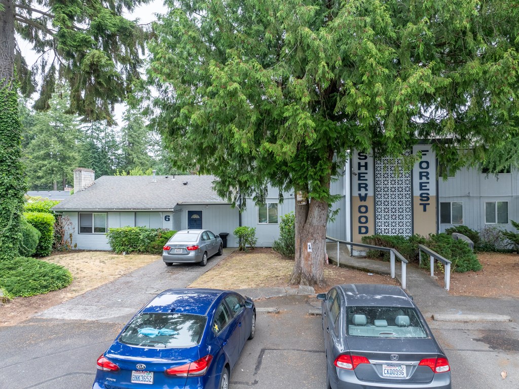 A carport with a sign that says "SHERIFF" is behind a blue car.