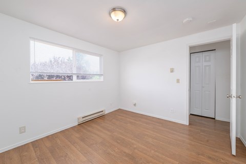 A room with a white door and a window with blinds.