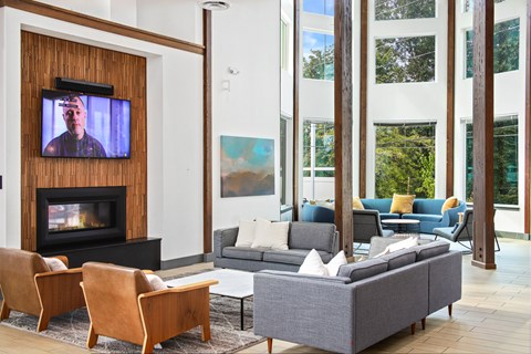A living room with a fireplace and a television on the wall.