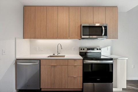A modern kitchen with wooden cabinets and stainless steel appliances.
