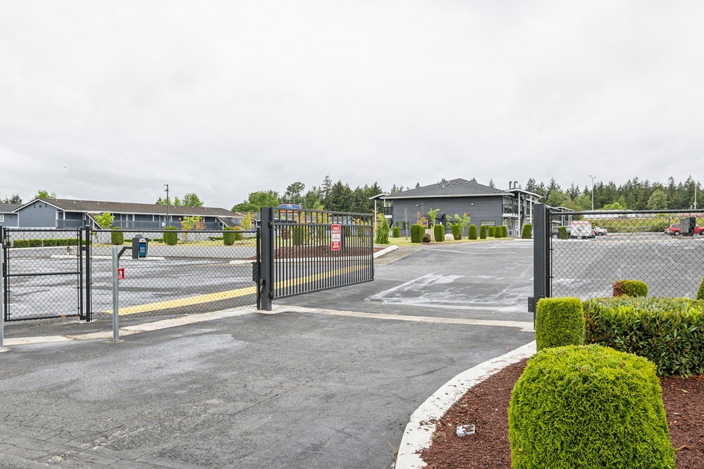 the entrance to a parking lot with a gate and buildings