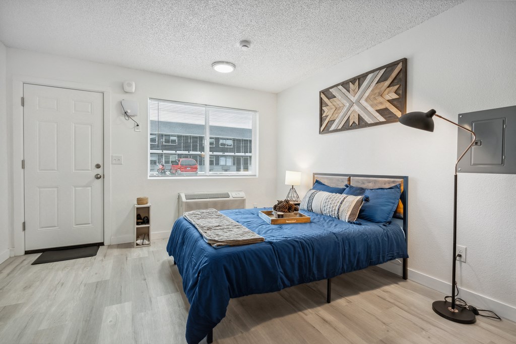 a bedroom with a bed and a lamp and a window