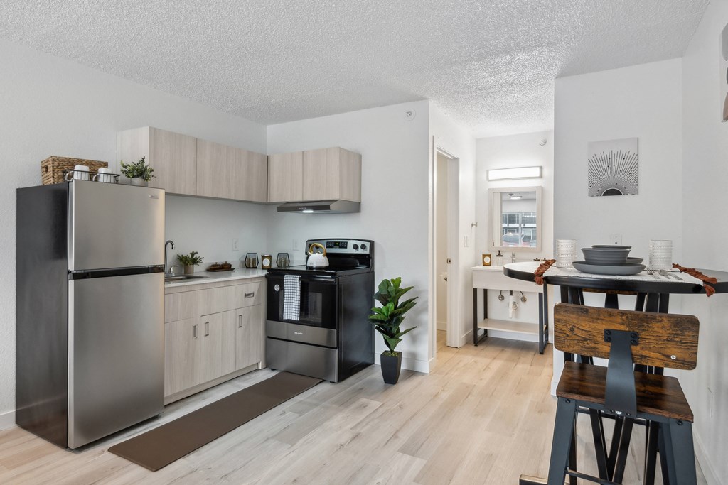 a kitchen and dining room with stainless steel appliances and wooden floors
