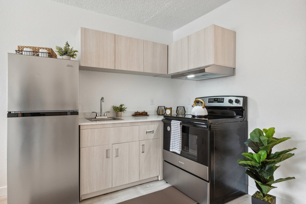 a kitchen with stainless steel appliances and wooden cabinets and a stainless steel stove and refrigerator