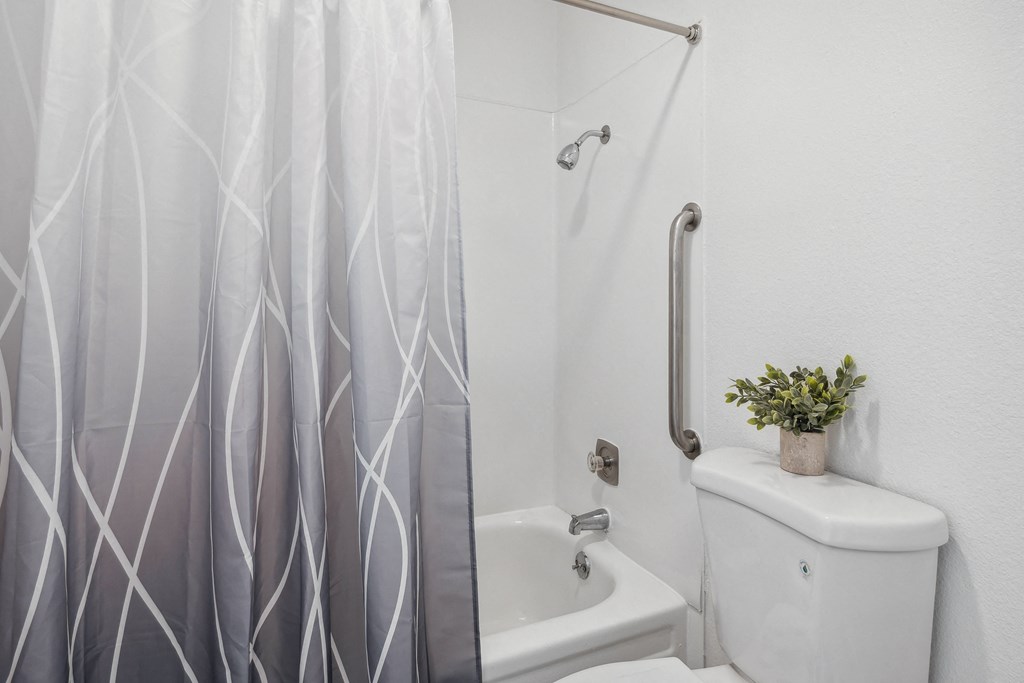 a bathroom with a shower and a toilet and a shower curtain