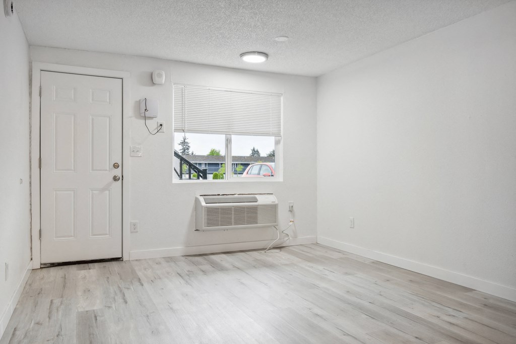 an empty room with white walls and a window