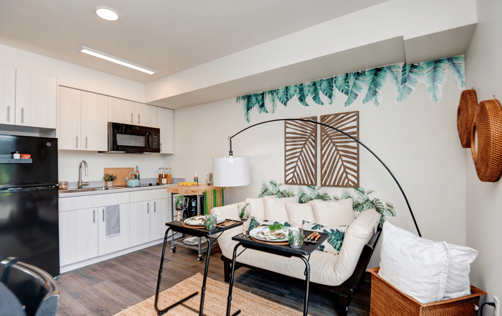 a living room with a couch and a table and a kitchen