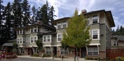 A row of houses with trees in front.