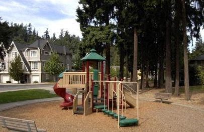 A playground with a red slide and a green roofed structure.