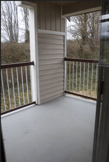 a screened in porch with a view of a yard and trees