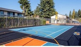 a blue and orange basketball court in front of a building