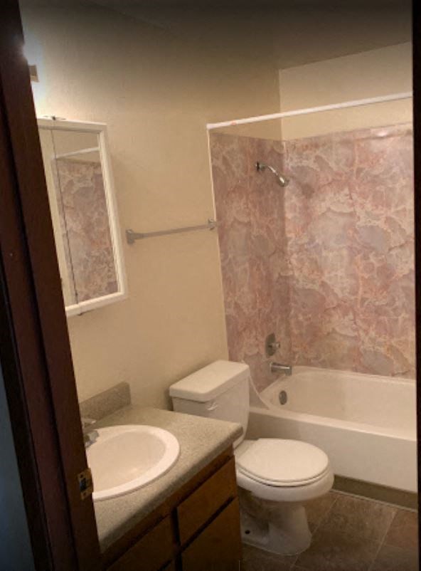 a bathroom with a toilet and a sink and a shower