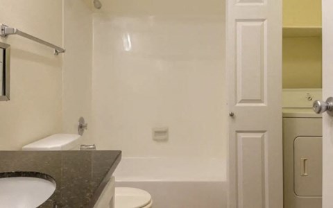 a bathroom with a toilet and a tub and a sink