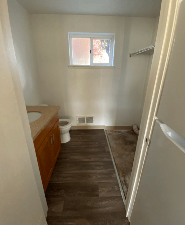 a small bathroom with a toilet and a sink and a window