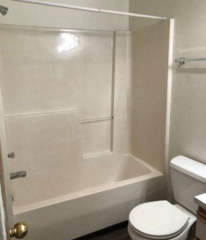 a white bathroom with a toilet and a tub