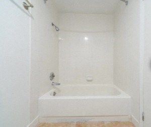 a white bathroom with a tub and a shower