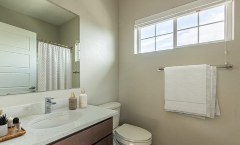 A bathroom with a white towel hanging on a towel rack.