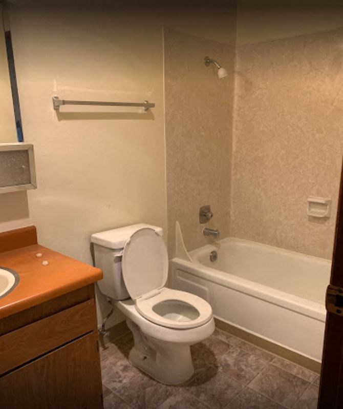 a bathroom with a toilet and a tub and a sink