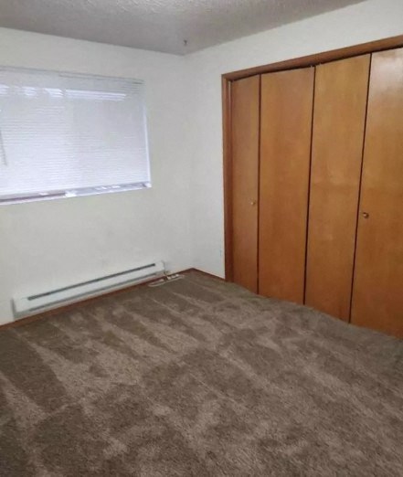 an empty room with a carpeted floor and a window