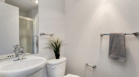 a white bathroom with a white toilet and a sink