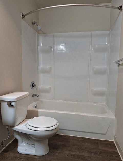 an empty bathroom with a toilet and a tub