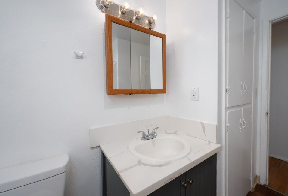 A bathroom with a white sink and a mirror above it.