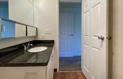 a bathroom with a sink and an open door