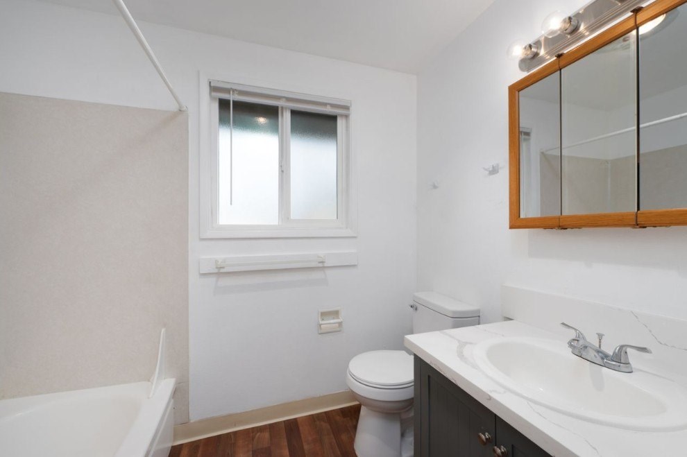 A white bathroom with a toilet, sink, and bathtub.