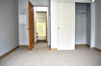 an empty room with an open door to a bathroom