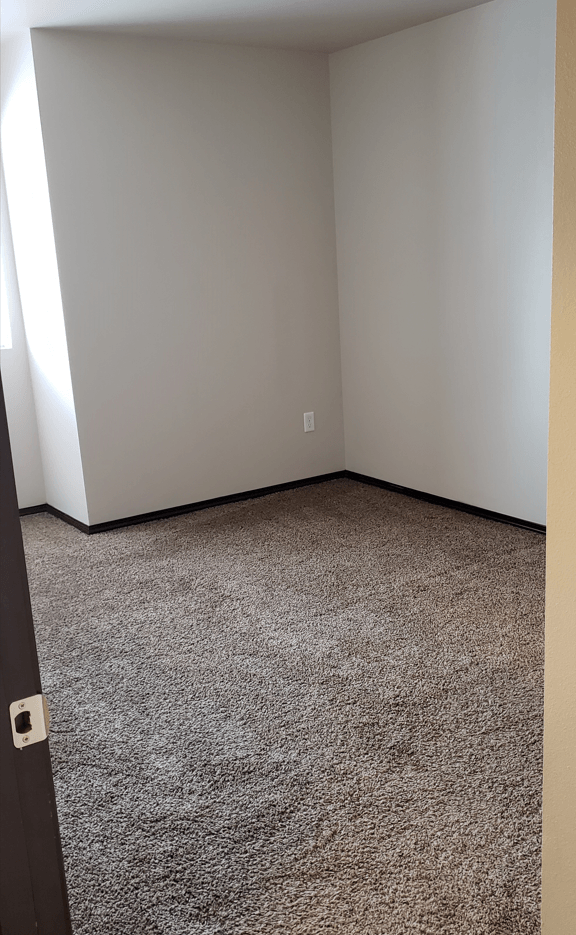 a room with a carpeted floor and a white wall