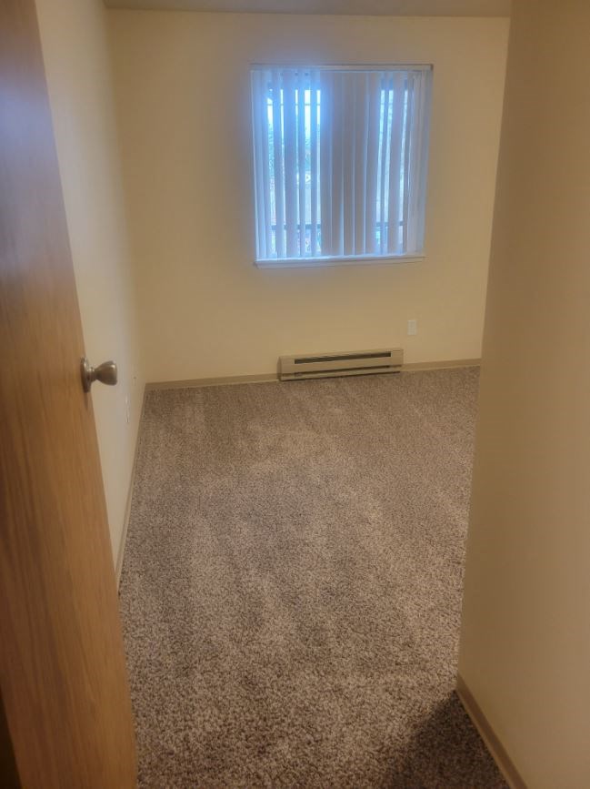 an empty room with a door and a window