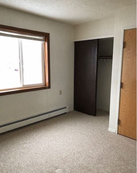 an empty room with a window and a closet