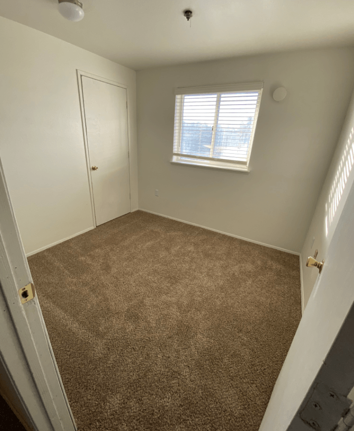 an empty room with a door and a window