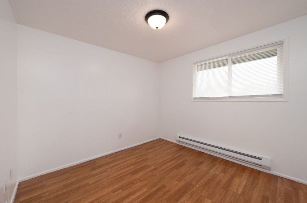 an empty living room with a large window and a closet
