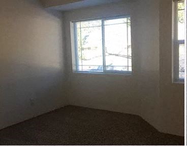 an empty room with a window and a carpet