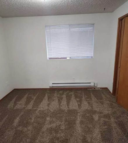 an empty room with a window and a carpet