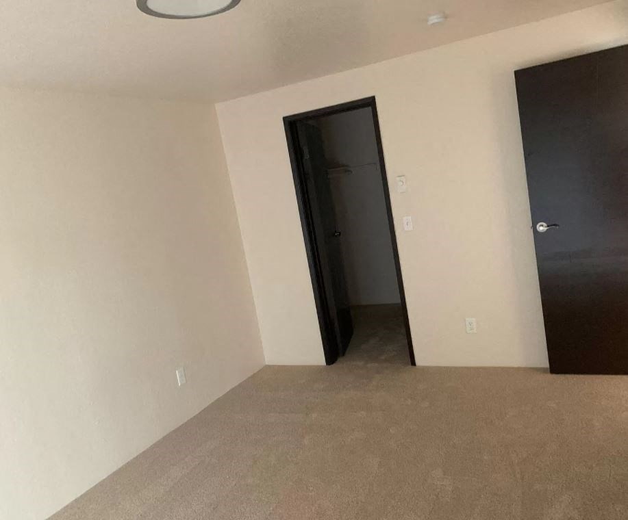 an empty living room with a door to a closet