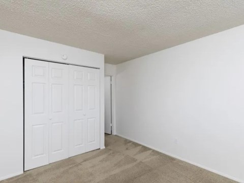A white door is in a room with white walls and carpet.