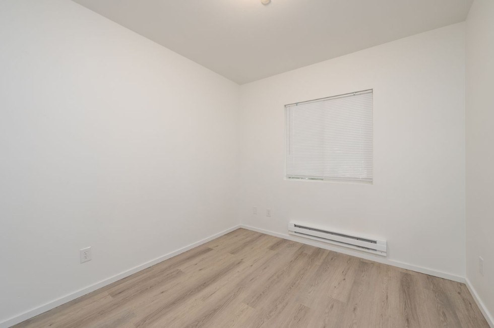 A room with a window and a radiator on the floor.