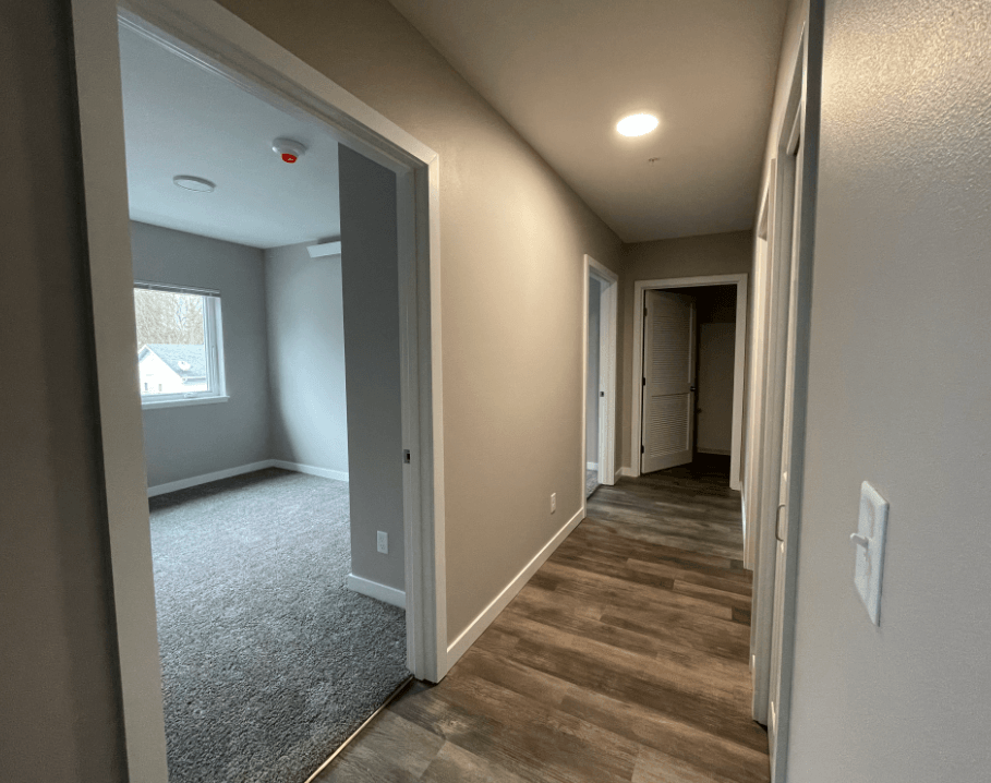 a hallway with a door to a bedroom and a window