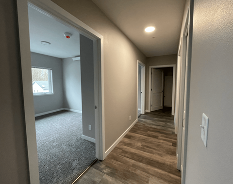 a hallway with a door to a bedroom and a window