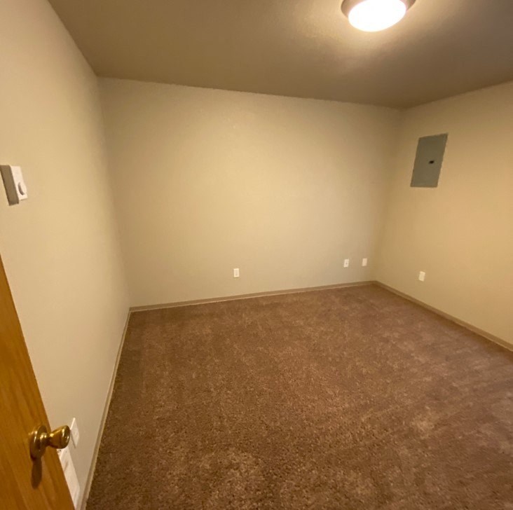 a empty room with a carpeted floor and a door