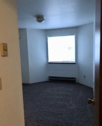 A room with a window and carpeted floor.